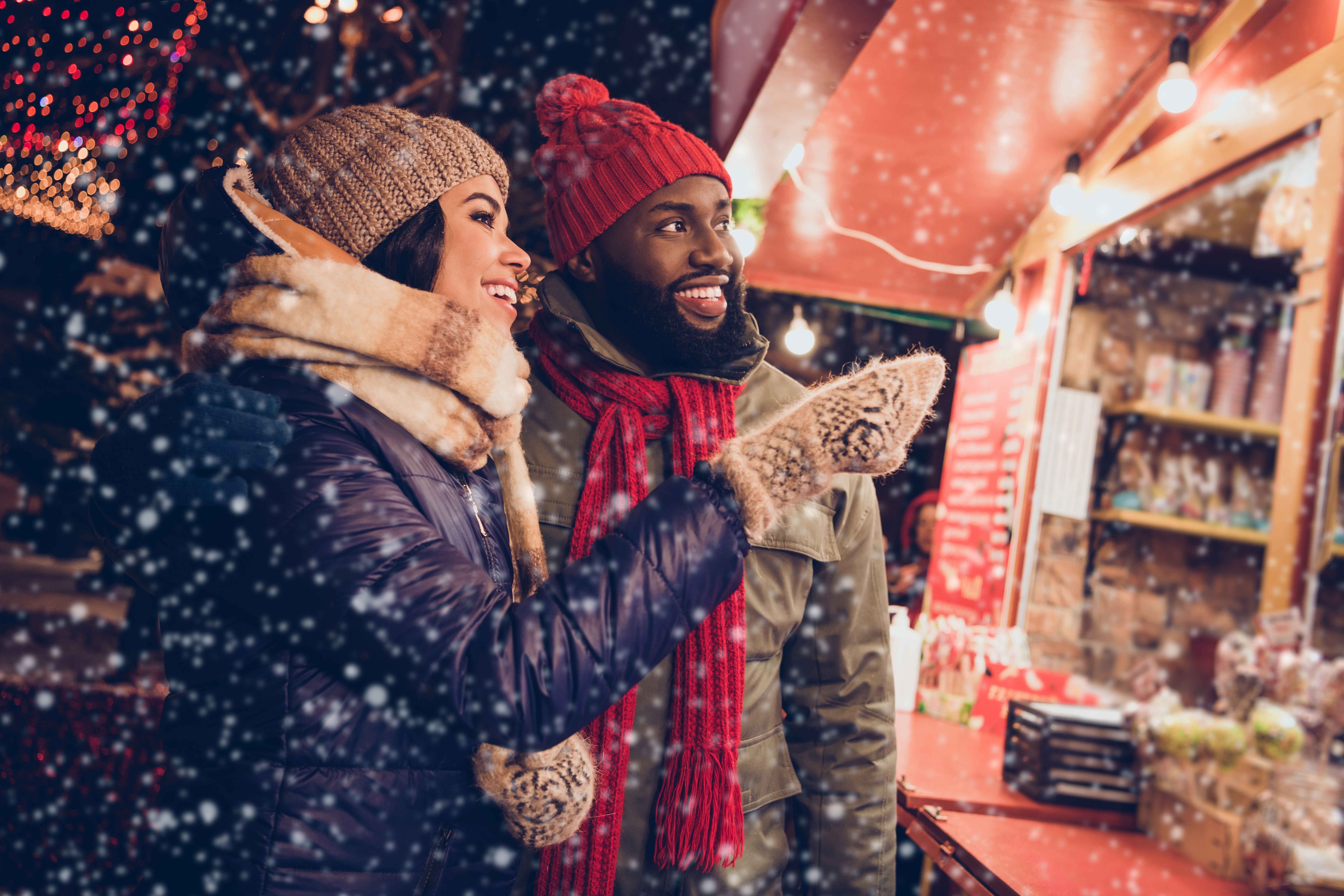 Couple at a Christmas market in the snow.